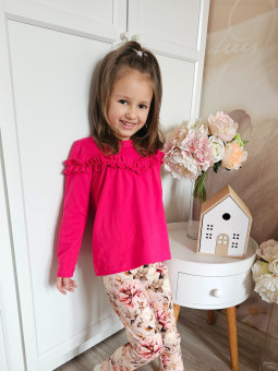 dziewczynka ubrana w gładka, różowa tunika z falbanką i leginsy w kwiaty